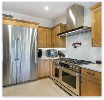 remodeled kitchen with white marble tops and rustic cabinets.