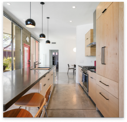 remodeled kitchen with white marble tops and white with brown cabinets.
