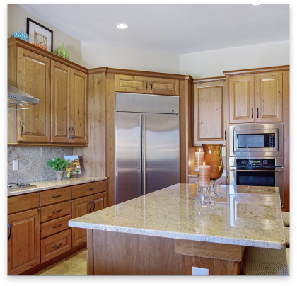 remodeled kitchen with white marble tops and rustic cabinets.