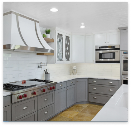 remodeled kitchen with white marble tops and grey cabinets.