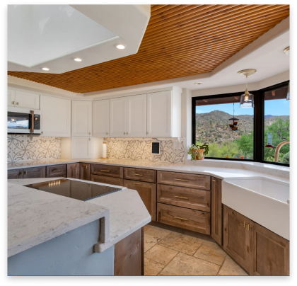 remodeled kitchen with white marble tops and rustic cabinets.