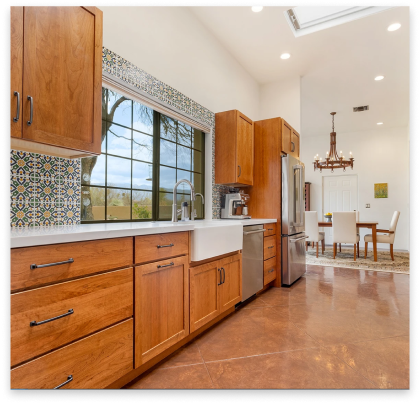 remodeled kitchen with white marble tops and brown cabinets.