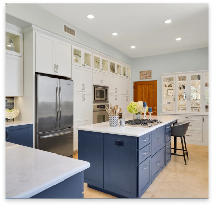 remodeled kitchen with white marble tops and blue cabinets.