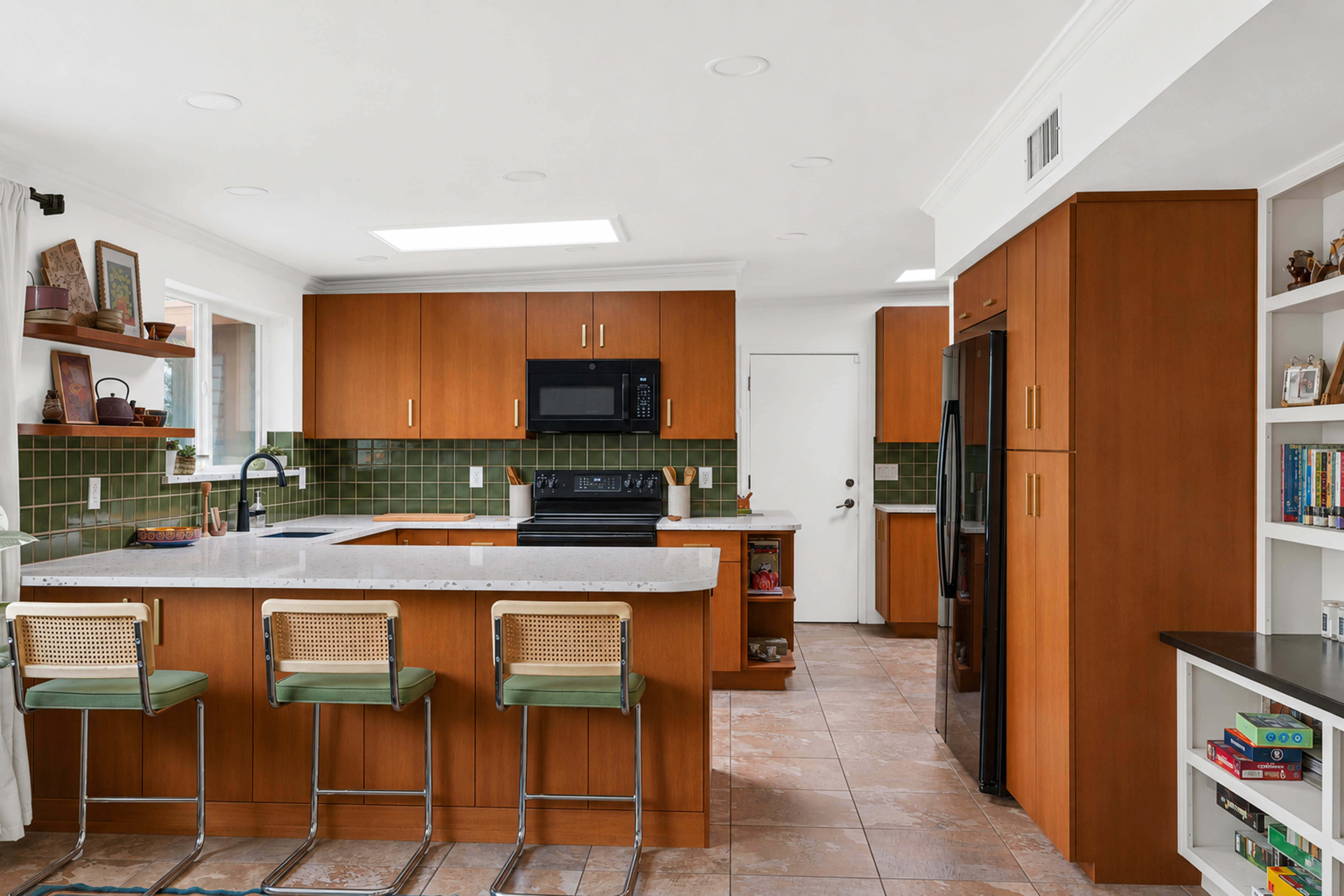 Modern kitchen remodel with wood cabinetry, green tile backsplash, white island countertop, and mid‑century bar stools.